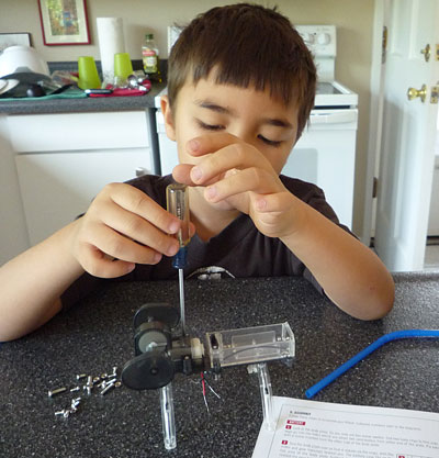 Ziad with screwdriver building a robot.